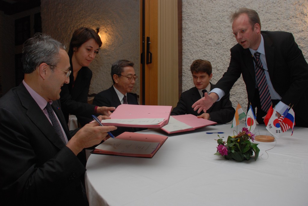 Kaname Ikeda, Bernard Bigot and François Gauché signing the Site Support Agreement. Akko Maas and Laetitia Grammatico assist with the documents. 