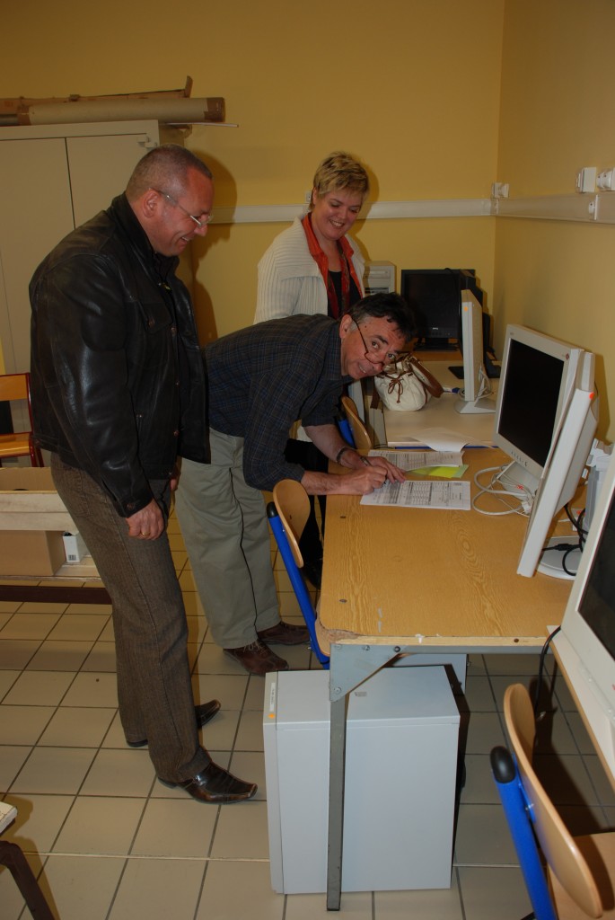 Eric Benoit and Nadine Utzel from the ITER team handing over the computer to school director André Barlatier. 