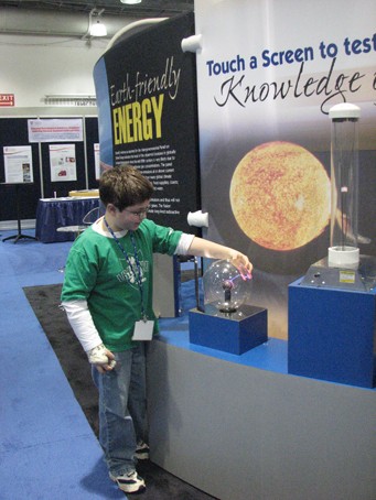 A student examines a plasma ball, one of several hands-on features of the U.S. ITER exhibit. (Click to view larger version...)